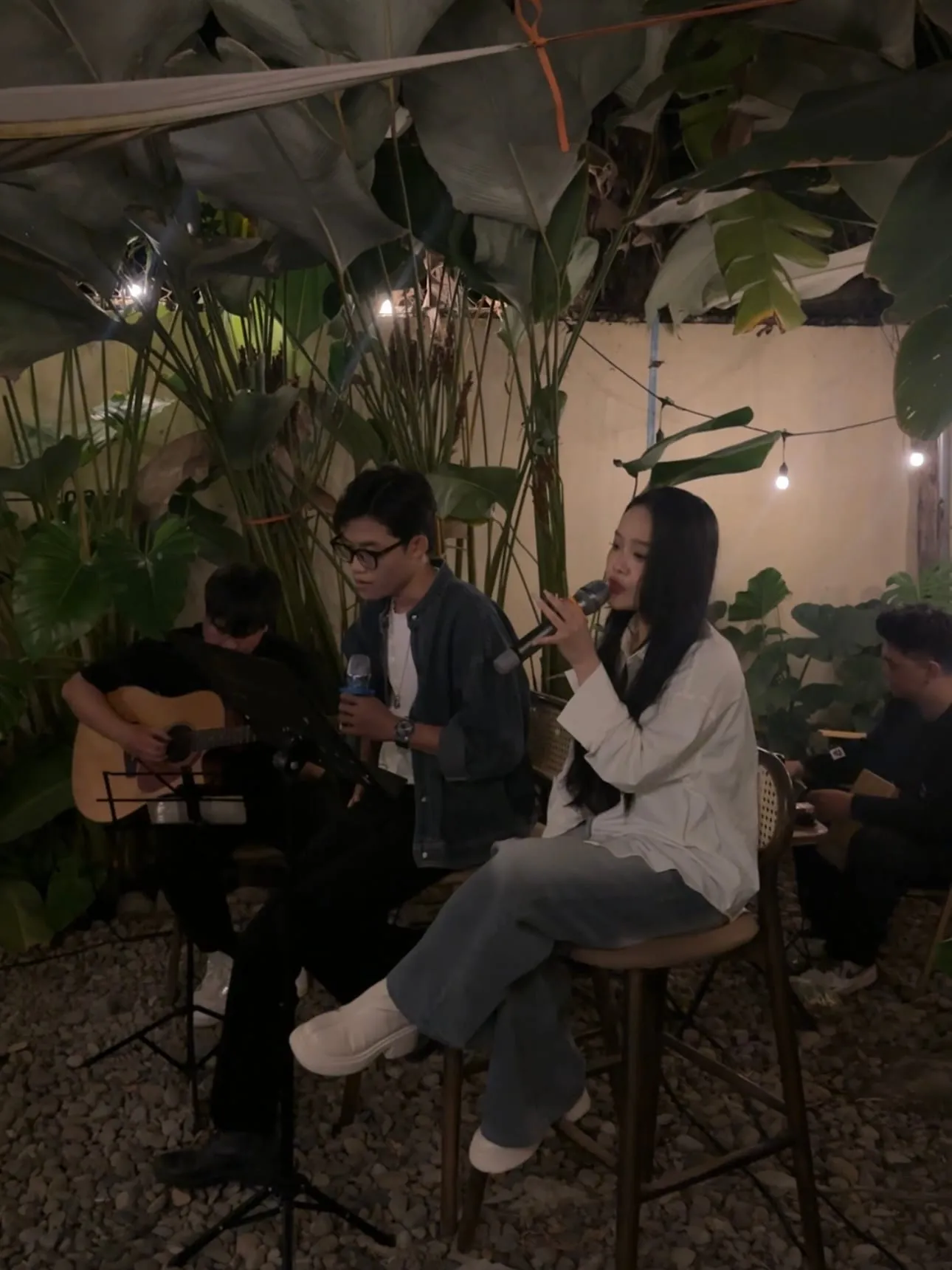 Đôi ca sĩ hòa giọng bên ban nhạc acoustic giữa sân vườn