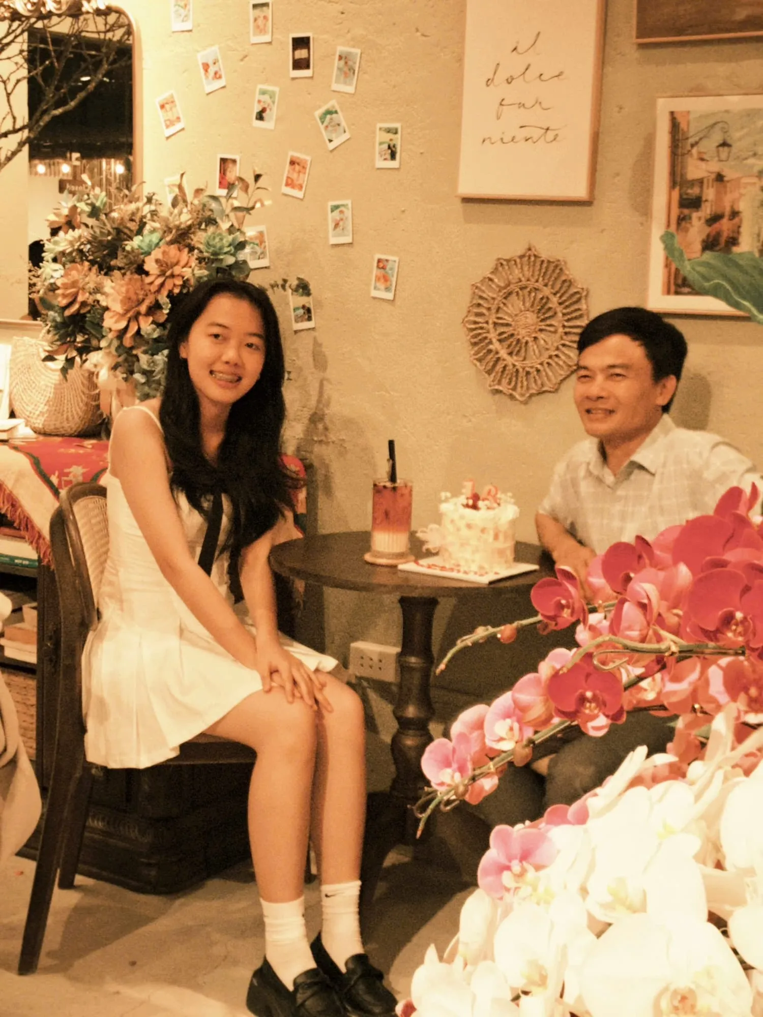 Hai khách thương nâng ly bên bàn đồ uống và hoa ở Hiên Nắng